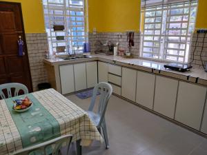 a kitchen with a table with a bowl of fruit on it at Hill View Paka Homestay in Paka