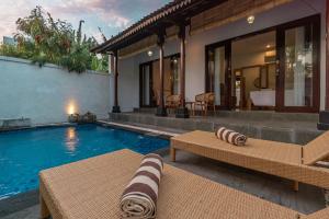 a villa with a swimming pool and a house at Sakya Villa Canggu By Bali Cabin in Canggu