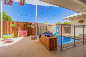 a backyard with a pool and a play area at Private Luxury Haven with SUV Hire, Pool, Near Marina in Trinity Beach