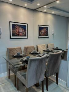 a dining room with a table and chairs at Apartamento Central 2 Quartos c Garagem in Pelotas