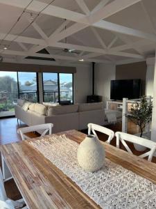 a living room with a table and a couch at Boutique Coastal Beach House Cowes Phillip Island Sleeps 8 in Cowes