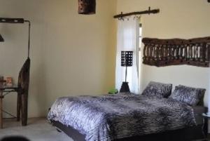 Un dormitorio con una cama y una lámpara. en Kashana Namibia, en Omaruru