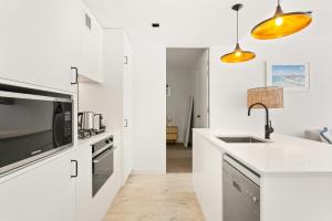 悉尼Sleek 2-Bed Apt Metres to Beach的带水槽和微波炉的白色厨房 更多13张照片