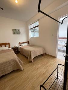 a bedroom with two beds and a large window at Hotel Isla Vela Paracas in Paracas