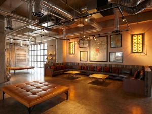 een grote kamer met een bank en tafels erin bij Kawasaki King Skyfront Tokyu REI Hotel in Kawasaki