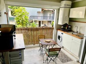 a kitchen with a table and chairs and a kitchen with a balcony at Studio confort près des plages in Le Gosier