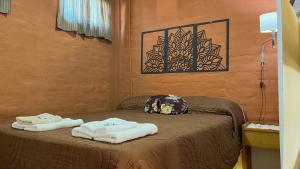 a room with a bed with towels on it at Refugio Mendoza in Godoy Cruz