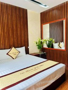 a bedroom with a bed with a wooden wall at Cúc Phương Mebi Hotel in Phủ Nho Quan