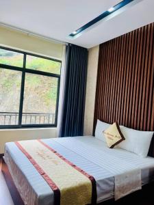a bedroom with a bed with a large window at Cúc Phương Mebi Hotel in Phủ Nho Quan +20 photos