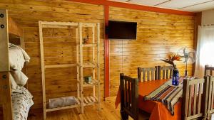 a room with a wooden wall with a table and a tv at Refugio Mendoza in Godoy Cruz