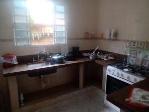 a kitchen with a sink and a stove top oven at Natureza Presente in São Lourenço
