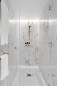 a bathroom with a shower with white marble walls at Harbour Views, Fireworks & Secure Parking in Sydney +11 photos