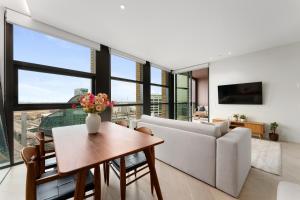 a living room with a couch and a table at Harbour Views, Fireworks & Secure Parking in Sydney
