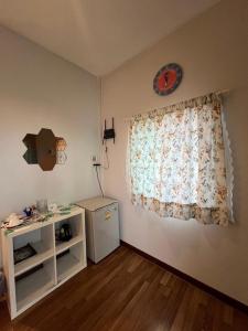 a room with a window with a dresser and a table at บ้านทอนบีช รีสอร์ท in Ban Thon