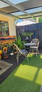 a patio with a table and chairs and flowers at Black Sheep Cottage Hay in Hay