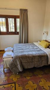 a bedroom with a large bed with a blue blanket at Antigua casa de bodega pax 4 in Maipú