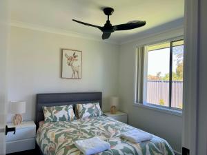 a bedroom with a bed and a ceiling fan at Paradise in Drysdale in Dubbo