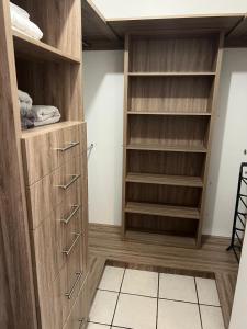 a walk in closet with wooden cabinets and shelves at Plácida casa cerca del consulado a 1500 metros del consulado americano in Ciudad Juárez