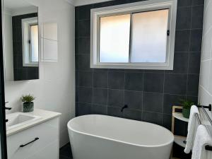 a bathroom with a white tub and a sink at Paradise in Drysdale in Dubbo +11 photos