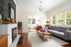 a living room with a couch and a fireplace at Winston Cottage at Three Sisters in Katoomba