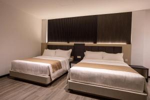 Postel nebo postele na pokoji v ubytování De Quinton Hotel