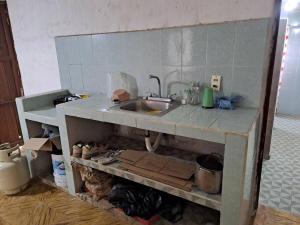 a kitchen with a sink and a cat under it at La Casa de More in Tizimín