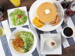 a table with plates of food and a cup of coffee at APA Hotel Ueno Hirokoji in Tokyo