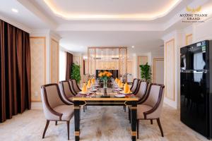 a dining room with a long table and chairs at Muong Thanh Grand Phuong Dong in Vinh