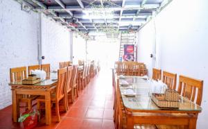 a dining room with wooden tables and chairs at Cat Ba Madame Duyen Hotel in Cat Ba