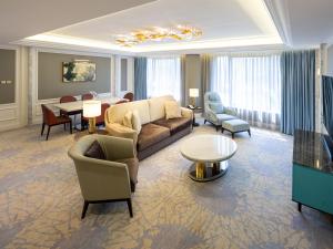 a living room with a couch and chairs and a table at Grand Emperor Hotel in Macau