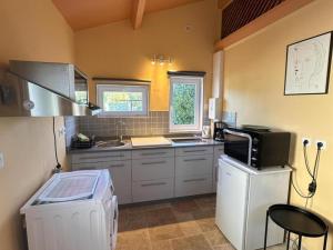 a small kitchen with a sink and a microwave at Studio à la campagne avec piscine partagée et jardin - FR-1-489-230 in Vendat
