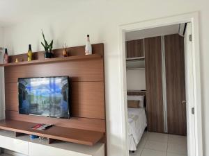 a living room with a tv on a wooden wall at RioStay Apart com varanda em frente Riocentro Farmasi Arena Parque Olímpico Globo Projac in Rio de Janeiro