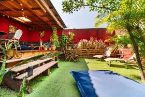 a patio with a bunch of plants and benches at Les Baroudeurs Hostel in Saint-Pierre