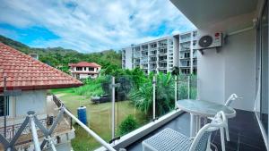 a balcony with a table and chairs on a balcony at Cosy 1 bedroom Chic condo in Karon Beach