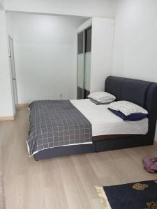 a bedroom with a large bed with blue pillows at Homestay Bandar Kajang in Kajang +3 photos