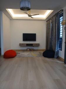 a living room with a flat screen tv and two pillows at Homestay Bandar Kajang in Kajang