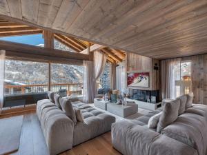 a living room with a large couch and a fireplace at Chalet neuf avec piscine chauffée, espace détente, sauna, bain nordique et salle de cinéma - FR-1-570-57 in Saint-Marcel