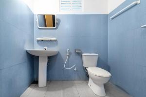 a blue bathroom with a toilet and a sink at Drifter - Rooms & Food in Midigama