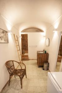 a hallway with a chair and a sink in a room at Vivez Bonifacio - La suite de Doria in Bonifacio