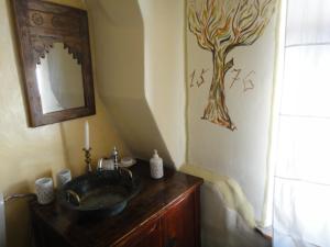 a bathroom with a sink and a tree painting on the wall at Dominic Boutique Tamplarilor in Sighişoara