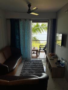 a living room with a couch and a large window at Panorama Seascape in Harnai +36 photos