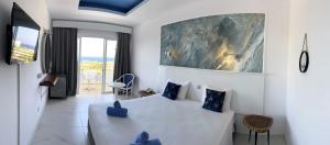 a bedroom with a white bed with blue pillows at Adelais Bay Hotel in Protaras