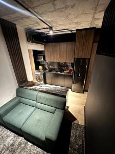 een woonkamer met een groene bank en een keuken bij Premier Monterrey Retreat 2 in Monterrey