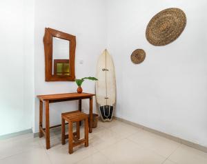 a room with a surfboard and a table and a mirror at Drifter - Rooms & Food in Midigama