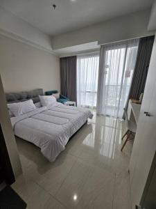 a bedroom with a large bed in a room at Green Sedayu Apartment Deluxe by Ellison in Jakarta +22 photos