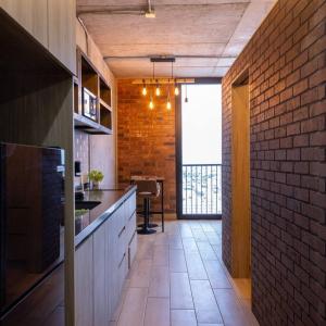 a kitchen with a brick wall and a dining room at Amazing Monterrey Getaway 3 in Monterrey