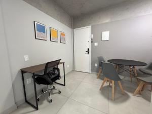 een kamer met 2 tafels en stoelen en een deur bij Apartamento Gonzaga Conforto in Santos