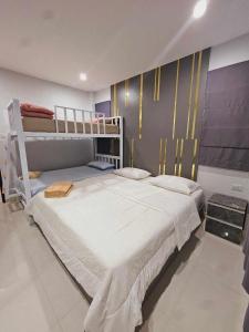 a bedroom with a large white bed and bunk beds at Mana Pool Villa in Ban Huai Yai +27 photos