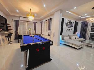 a living room with a pool table and a couch at Mana Pool Villa in Ban Huai Yai