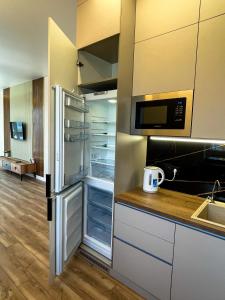 a kitchen with a refrigerator with its door open at Luxury apartment Atlant in Astana